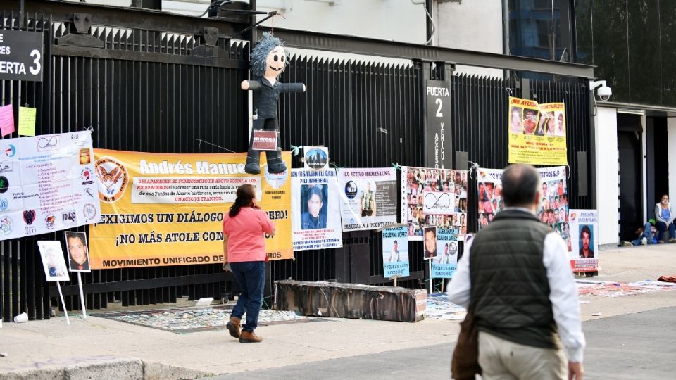 Fotografías de personas desaparecidas y víctimas del delito fueron colgadas en un tendedero, en las rejas de la Cámara alta. Foto: Guillermo O’Gam