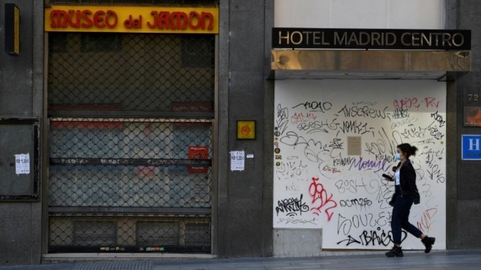 Mujer camina por calle solitaria en Madrid. Foto: AFP