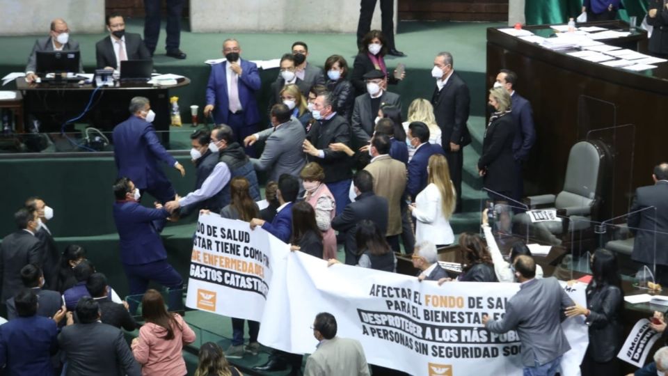 La trifulca comenzó cuando la morenista Ángeles Huerta estaba en tribuna, misma que fue tomada por legisladores
de oposición. Irma Juan Carlos, de Morena, jaló de la corbata al panista Miguel Riggs. Foto: Cuartoscuro