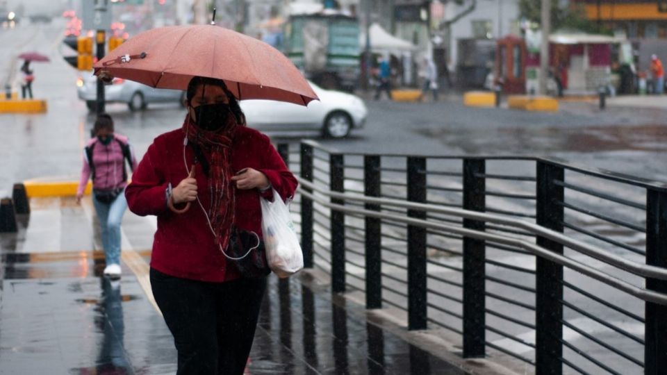 Una mujer camina rumbo a la estación Centro Médico bajo la lluvia. FOTO: DANIEL AUGUSTO/CUARTOSCURO.COM