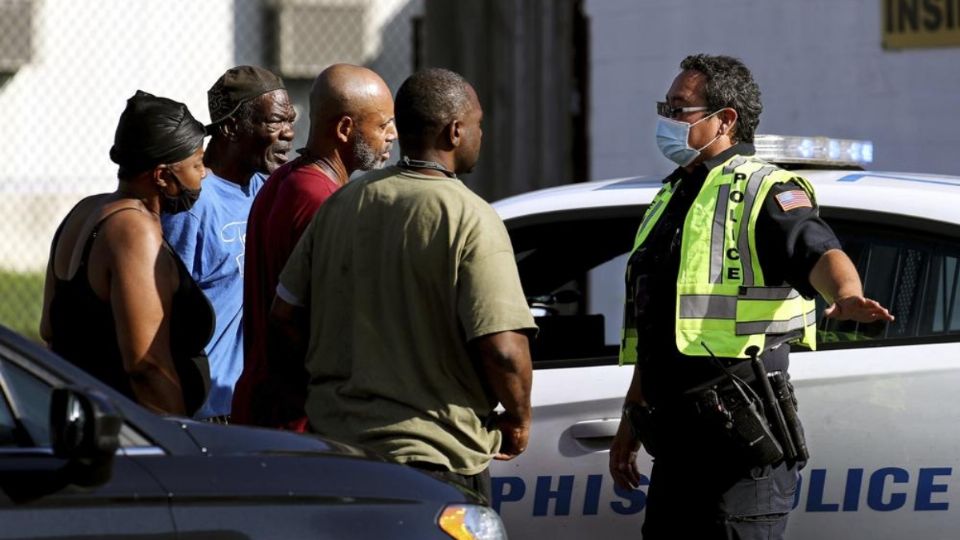 Familiares de las víctimas esperan con los oficiales en las inmediaciones de la Oficina de Servicio Postal (Foto: AP)