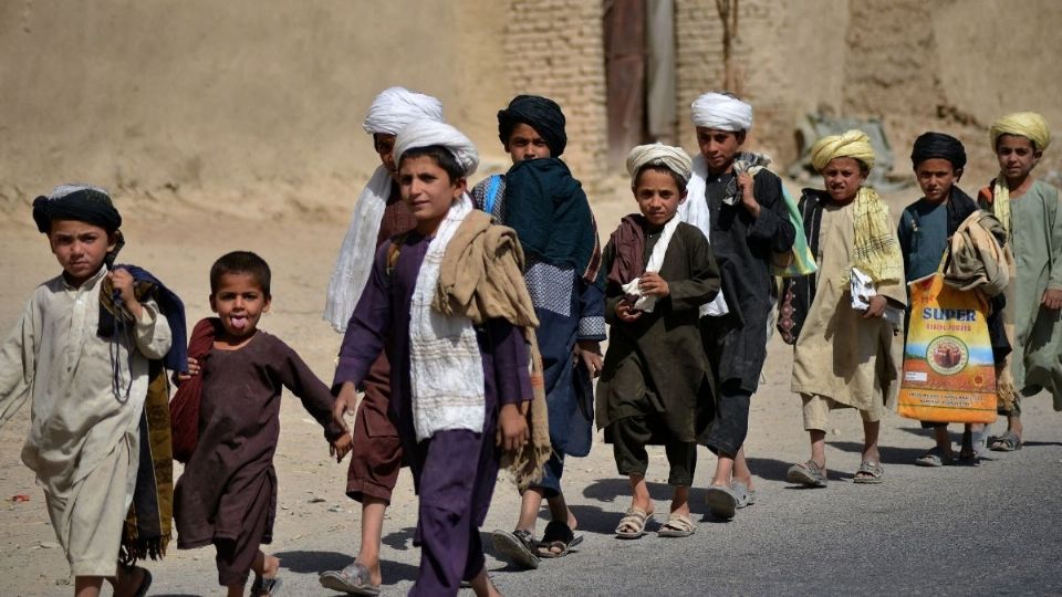 REGRESO. Niños van a sus casas, tras salir de la escuela. Foto: AFP