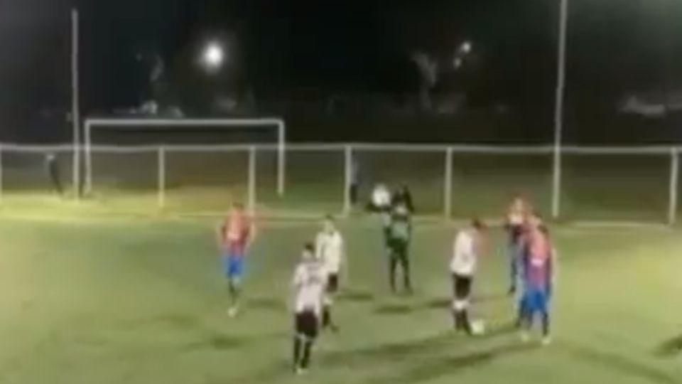 Un hombre entra a la cancha para disparar contra el árbitro y otro sujeto golpea a los jugadores. Foto: Especial