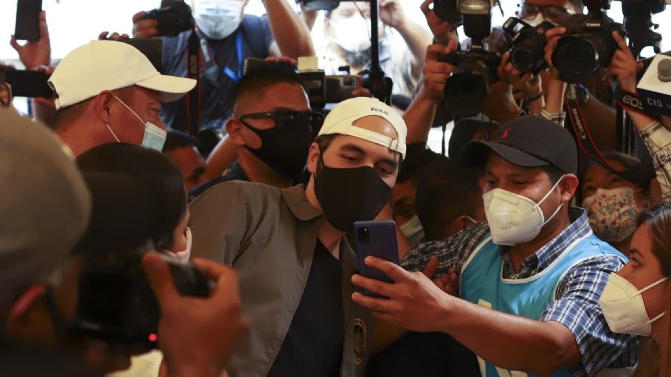 El mandatario Bukele posó para una selfie con un trabajador electoral, tras ir a sufragar. Foto: AP