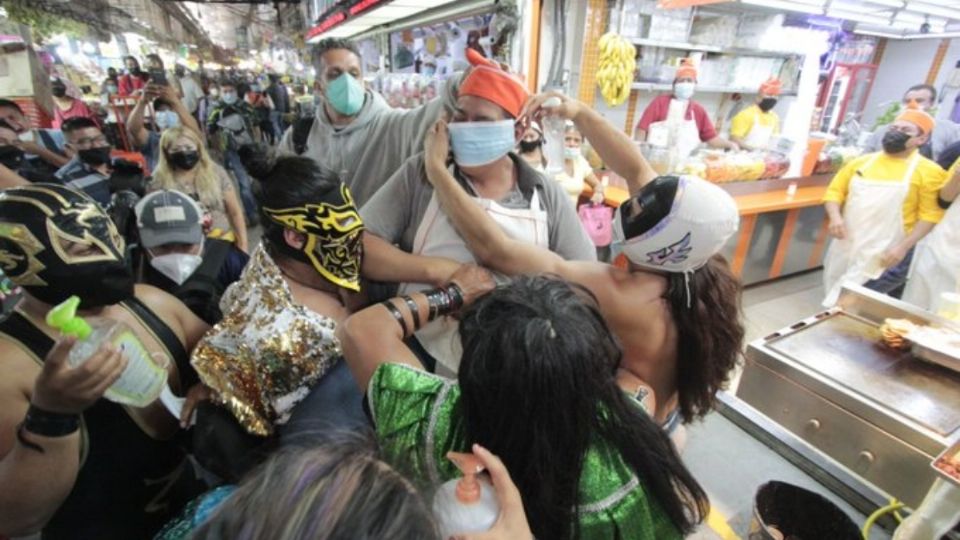 Los luchadores acudieron a poner cubrebocas a los comerciantes. Foto: Injuve