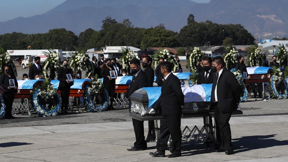 LUTO. Las familias, con coronas de flores y fotografías de sus familiares, recibieron los ataúdes. Foto: AP