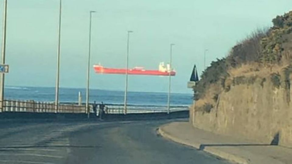 La quilla del barco está fuera de la vista y, junto con las nubes bajas, parece difícil ver dónde termina el agua.