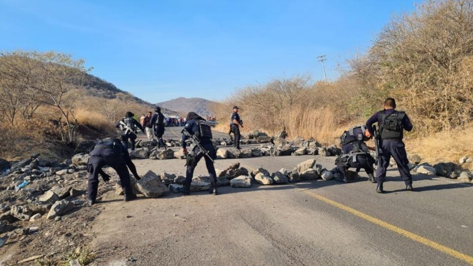 APOYO. Luego de varias horas de cierres, policías retiraron las grandes piedras que impedían el paso por la zona. Foto: Especial