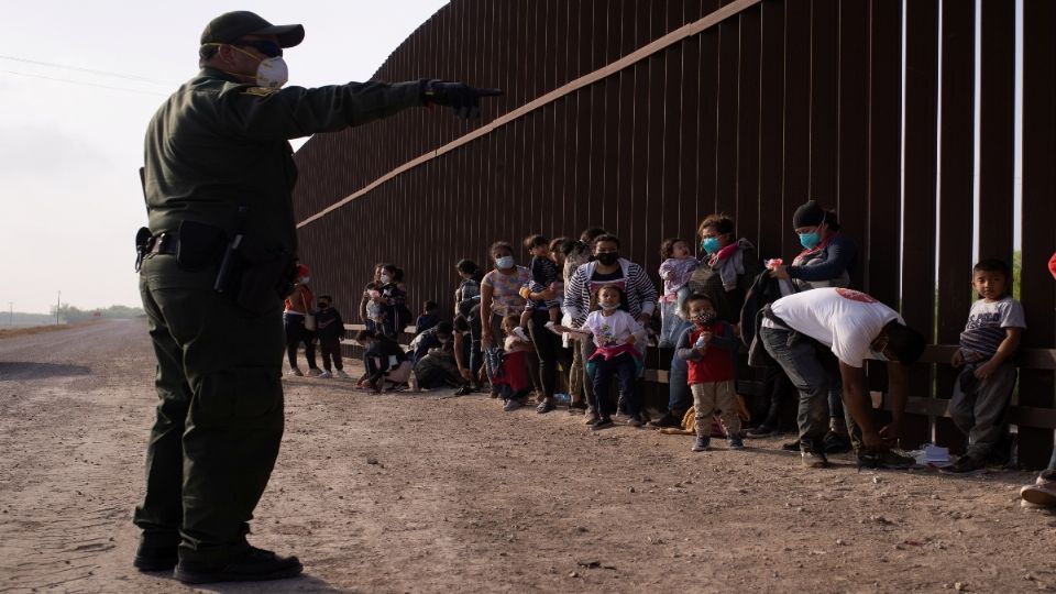 Un agente de la Patrulla Fronteriza instituye a los migrantes que buscan asilo.