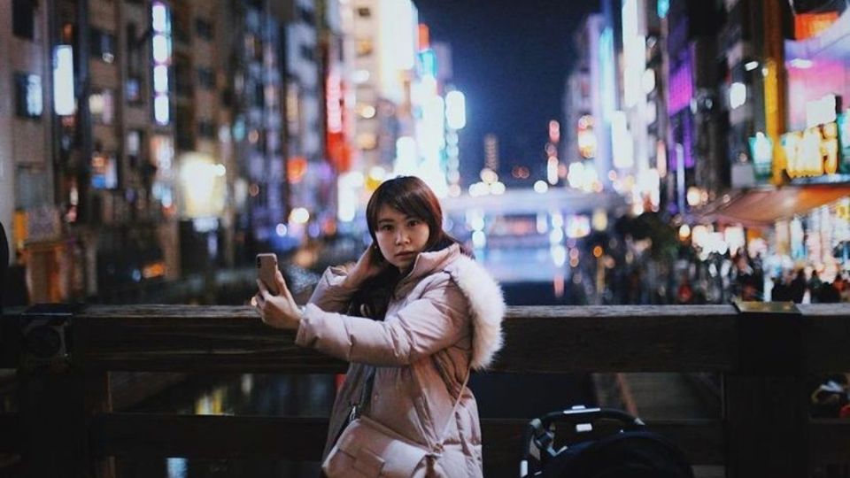 Chica se toma una foto con su celular en la ciudad de Osaka, Japón. Foto: IG @elchadsantos