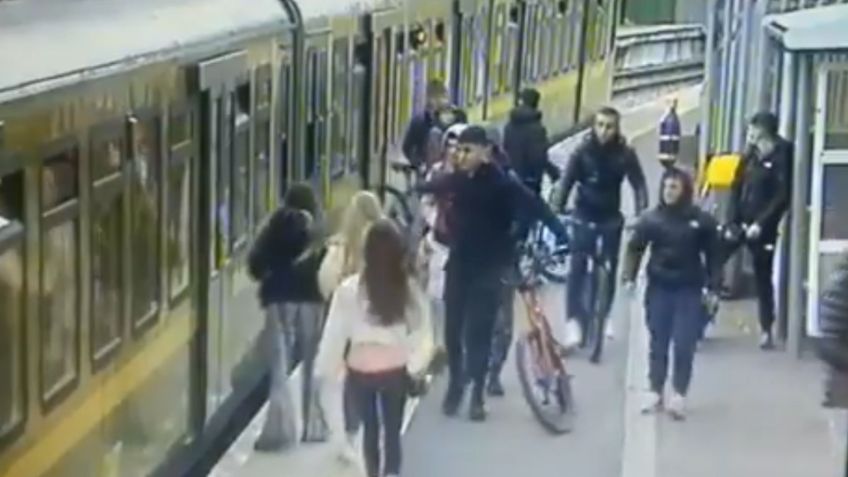 Hombres acosan a mujer y causan que caiga a las vías del tren: VIDEO