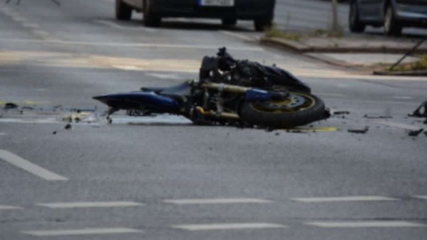 IMÁGENES FUERTES: Motociclista se impacta contra combi y queda atrapado en la parte trasera