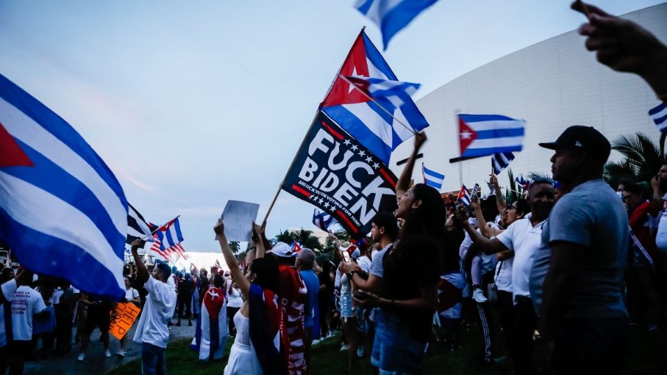 MIAMI. Una persona sostuvo una bandera antiBiden, mientras la gente agitaba banderas cubanas y estadounidenses. Foto: AFP