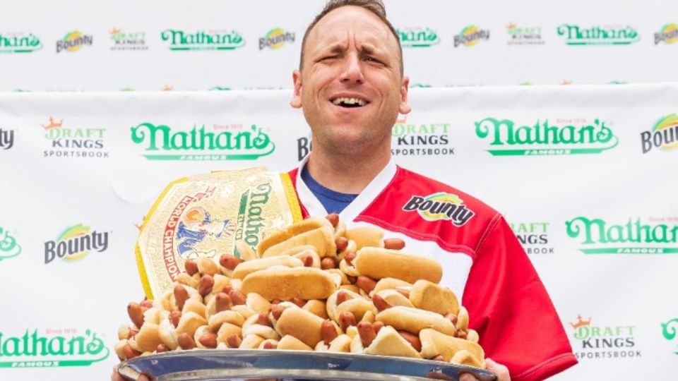 Joey Chesnut sosteniendo una bandeja con hot dogs. Foto: EFE