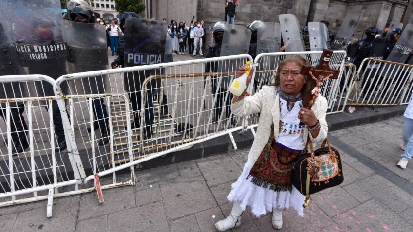 Con crucifijo en mano, mujer rocía agua bendita a feministas durante marcha en Toluca | VIDEO