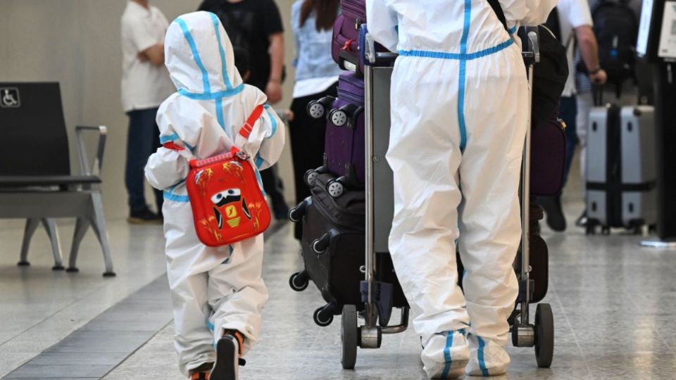 Un pequeño camna junto a su padres para dirigirse a un vuelo en los Estados Unidos. Foto: AFP