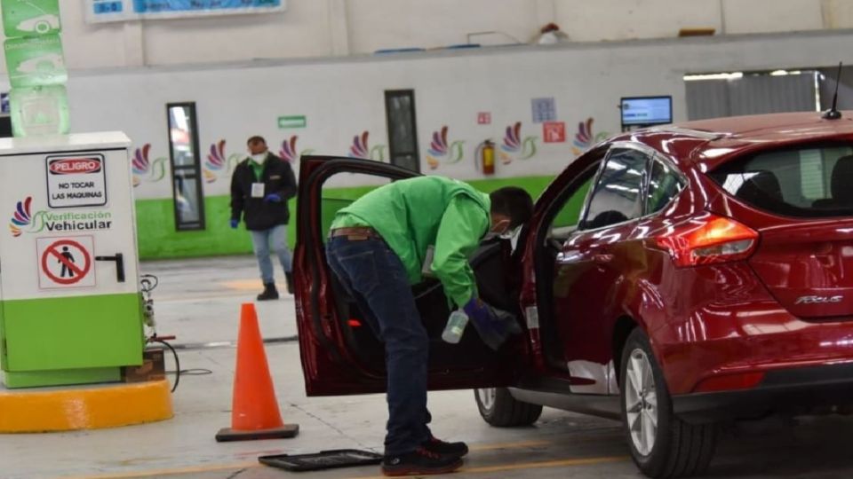 Tranbajador de un centro de verificación proceso para checar auto. Foto: Cuartoscuro.