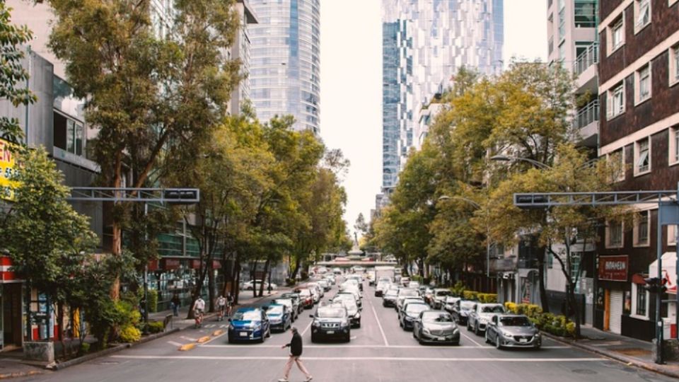 Un señor camina sobre Avenida Reforma.