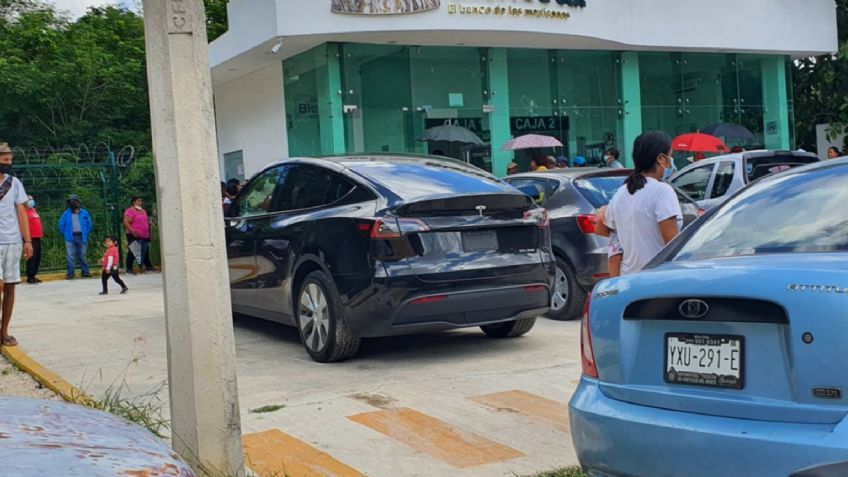 Captan costoso auto Tesla afuera de Banco de Bienestar y desata polémica: "Se regala dinero a quien no lo necesita"