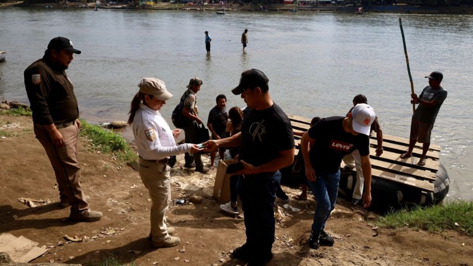 Los ciudadanos venezolanos buscan a agentes de INM para ser conducidos a la estación migratoria, en Chiapas