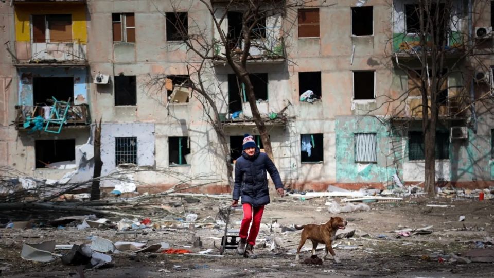 Una persona saca a pasear a su perro en una zona asediada por los bombardeos. FOTO: AP