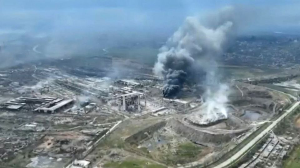 Nubes de humo que se elevaban sobre la planta de acero de Azovstal y puertas destruidas del astillero de Azov