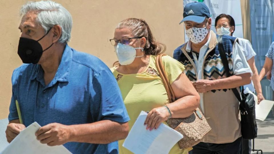 Adultos mayores hacen fila durante feria del trabajo.