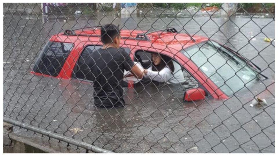 Una pareja quedó atrapada en su auto por la fuerte lluvia.