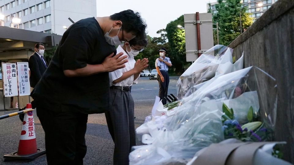 LUTO. Dolientes ofrecieron flores para el expremier Abe, en la entrada de la sede de su partido