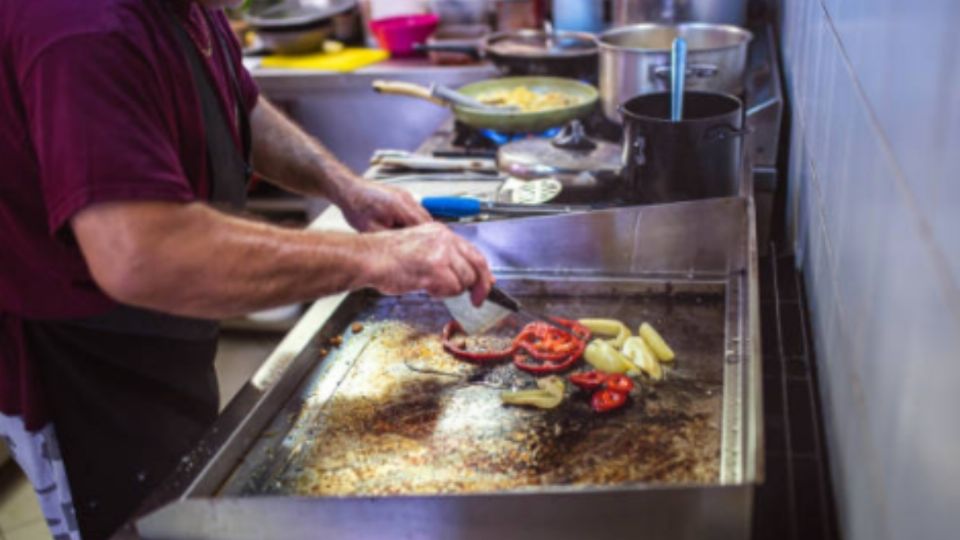 Un taquero trabajando en su local de comida.