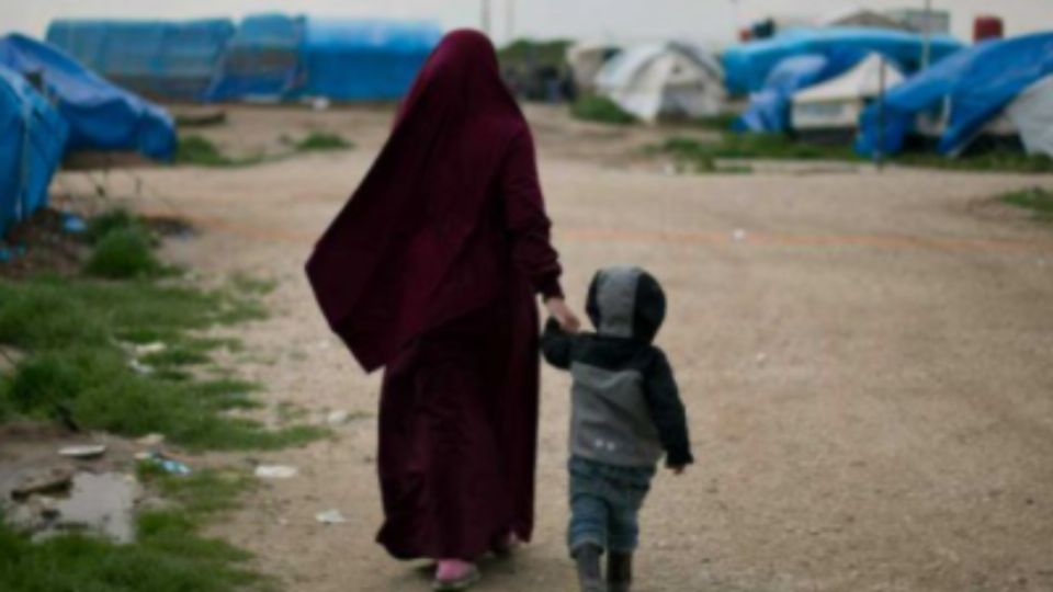 Una mujer camina por un campo de refugiados.