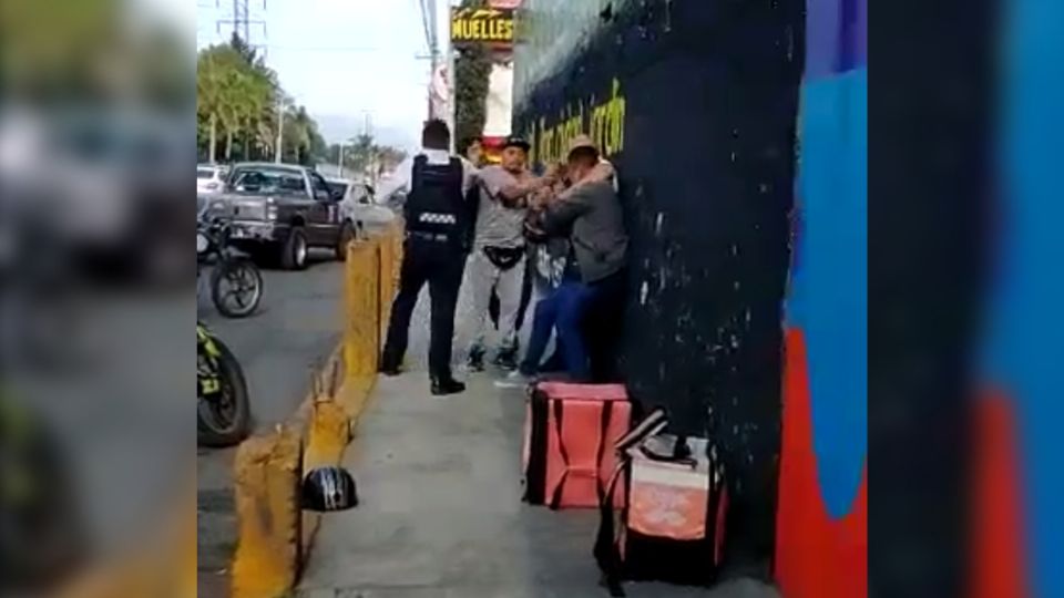 En el video, se observa como elementos municipales someten al repartidor; mientras una mujer grita cuestionando la acción policial