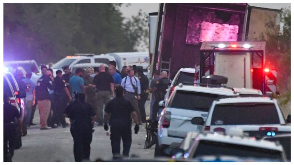 Policías de Texas custodian un tráiler abandonado con decenas de migrantes.