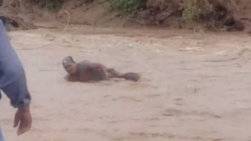 El increíble momento en que un hombre es rescatado con un lazo tras ser arrastrado por corriente | VIDEO