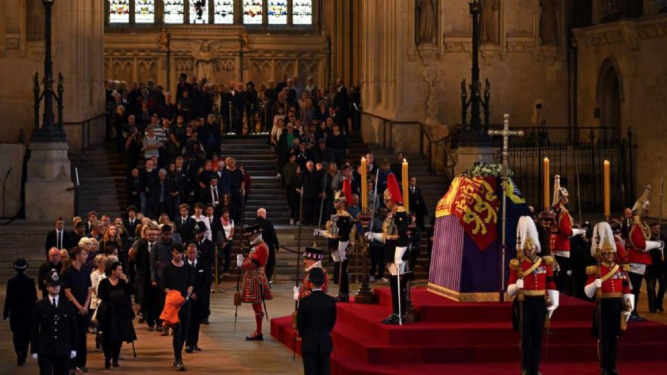 Ciudadanos presentan sus respetos al pasar junto al ataúd de  Isabel II dentro del Palacio de Westminster.