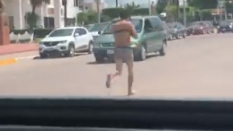 Se aprecia al hombre con los brazos atados y ocultándose el rostro con una gorra, el cual solo llevaba puestos 'boxers'