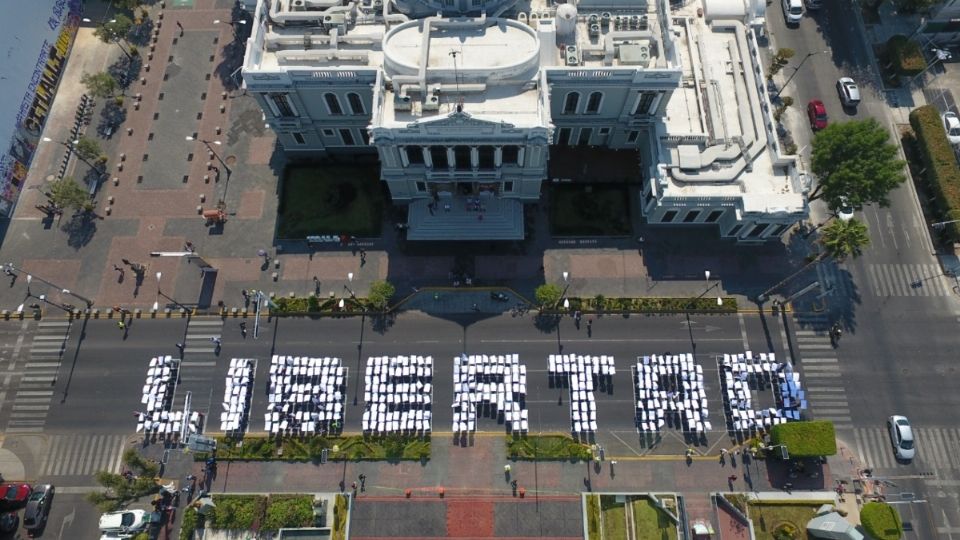 Trabajadores de la Universidad de Guadalajara formaron la palabra libertad en protesta por la detención de tres alumnos.