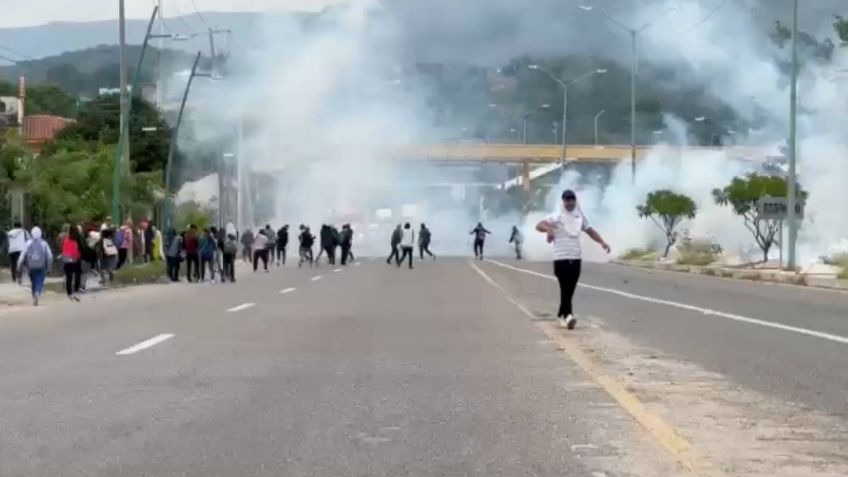 Estudiantes normalistas se enfrentan a policías durante el bloqueo de una caseta en Chiapas