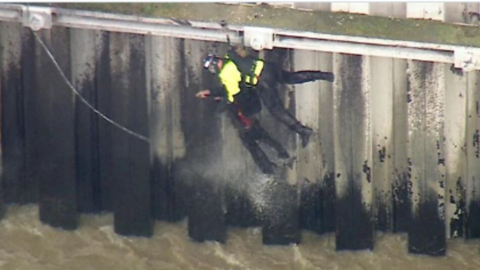 En un video difundido de manera amplia en redes sociales, muestran al hombre aferrándose a un muro en busca de no ser arrastrado por la fuerte corriente.