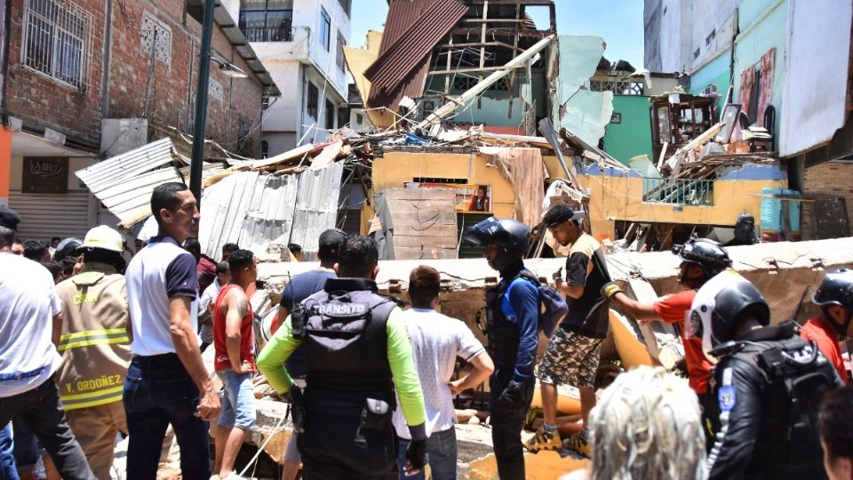 Residentes y rescatistas frente a los edificios derribados por el terremoto.