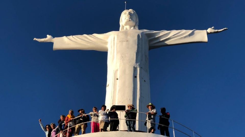 Hacen senderismo hacia un faro para tomarse fotos en un Cristo en el lugar