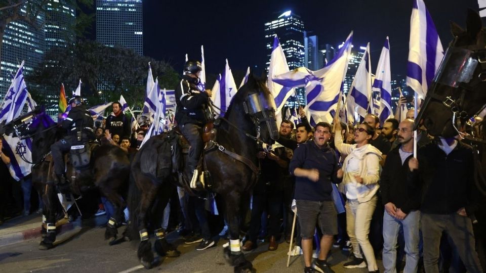 La policía israelí montada hace guardia mientras los manifestantes asisten a una reunión en Tel Aviv el 27 de marzo de 2023.