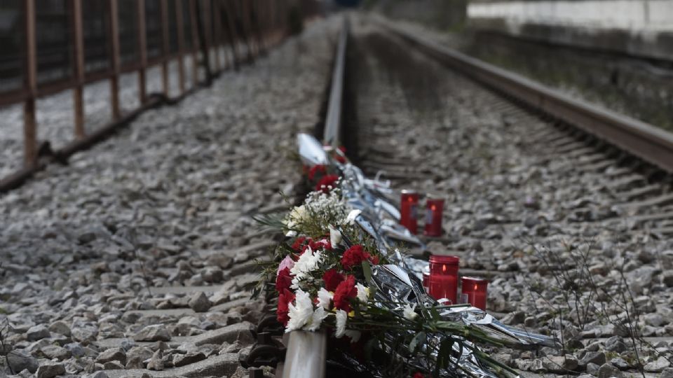 Una foto muestra flores colocadas en las vías de la estación de tren de Rapsani, en el norte de Grecia, el 5 de marzo de 2023, durante una reunión conmemorativa de las víctimas de un accidente de tren mortal en el que murieron 57 estudiantes y residentes del municipio de Tempi.