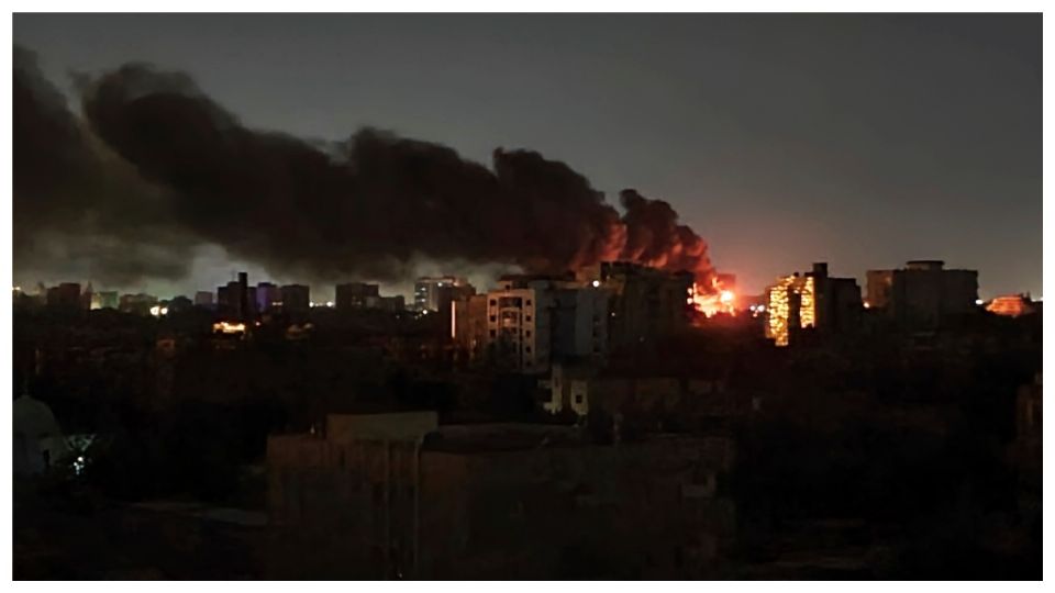 El humo se eleva sobre el horizonte mientras arde un edificio después de un ataque en Jartum, Sudán