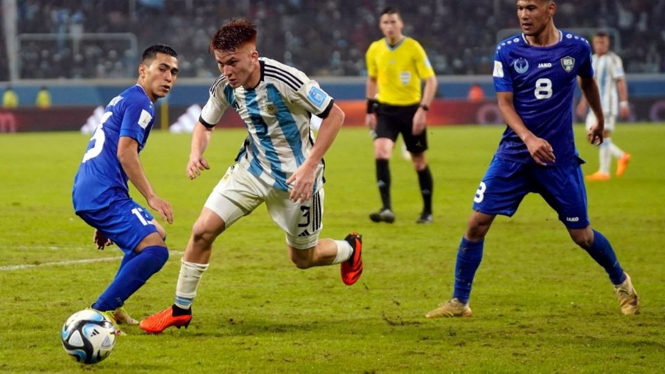 El defensor argentino Valentin Barco (C) compite por el balón con el defensor de Uzbekistán Zafarmurod Abdurahmatov (I) y el mediocampista Bekhruzbek Askarov.