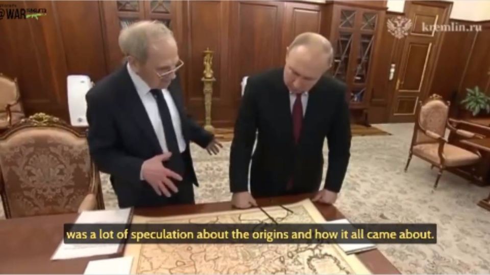 Putin mirando un mapa antiguo al hablar sobre la historia de Ucrania.