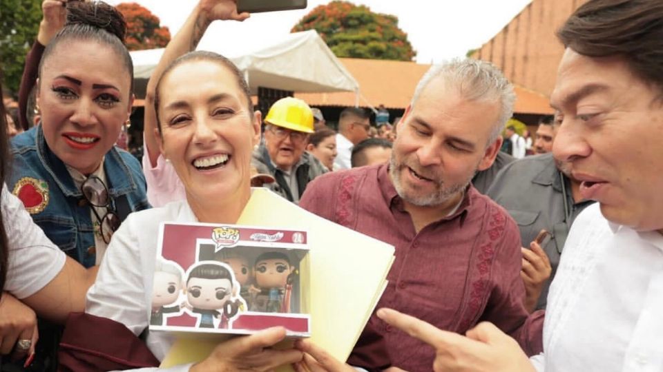 Claudia Sheinbaum recibió el regalo en Morelia, la observan sorprendidos Mario Delgado y Alfredo Ramírez Bedolla.