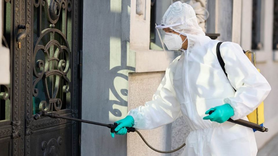 Hombre fumigando entrada de casa para evitar transmisión del virus del dengue