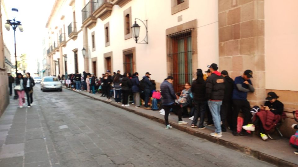 Cientos de personas de todas las edades forman una enorme fila en torno al Palacio de Gobierno.