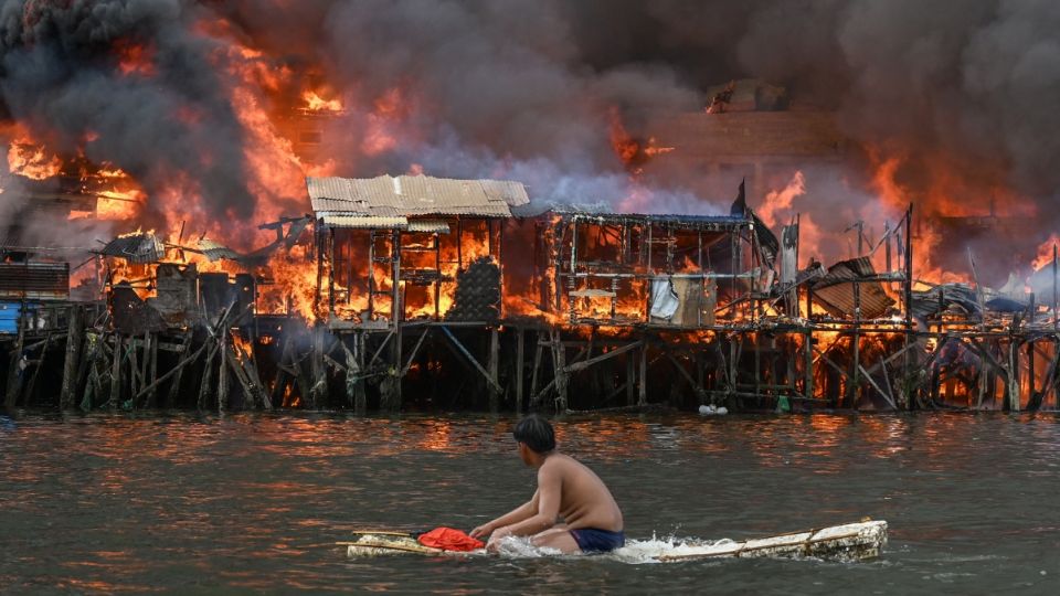 Un hombre observa casas en llamas en Tondo, Manila, el 24 de noviembre de 2024.